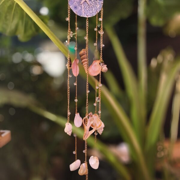 Handmade Azulejos coastal shell suncatcher by Panda Crafts with blue-and-white ornamental design, starfish detail, real seashells and metallic chains.